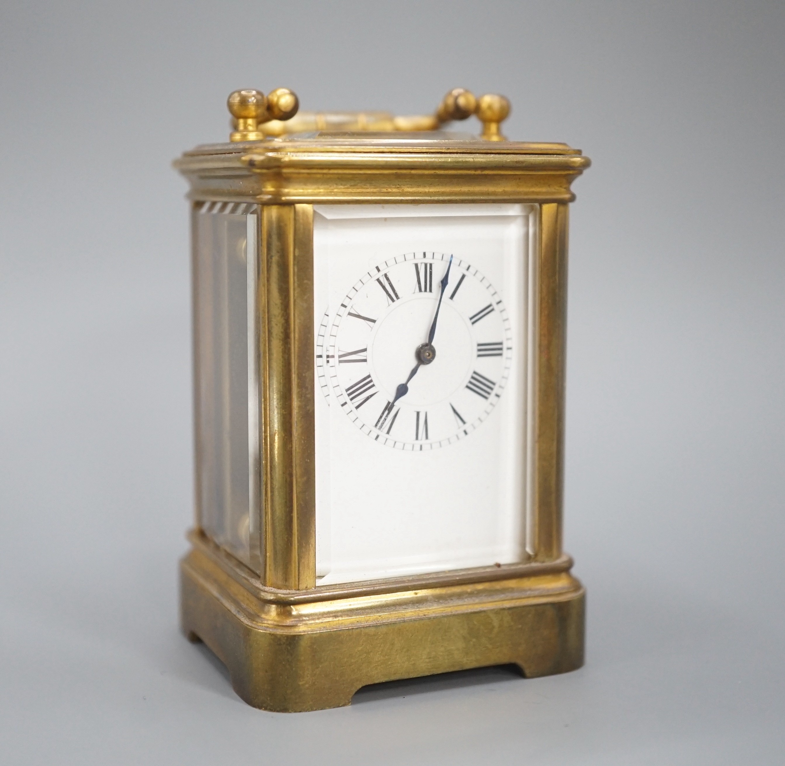 A Henri Jacot brass miniature carriage timepiece, 9.7 cm high with the handle up, cased